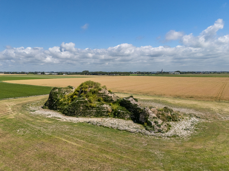 Aerial view of the Dijk van een wijf sculpture situated in a rural landscape surrounded by agricultural fields under a blue sky in Oosterbierum Friesland Netherlands. Aerial view of the Dijk van een wijf sculpture situated in a rural landscape surrounded by agricultural fields under a blue sky in Oosterbierum Friesland Netherlands.