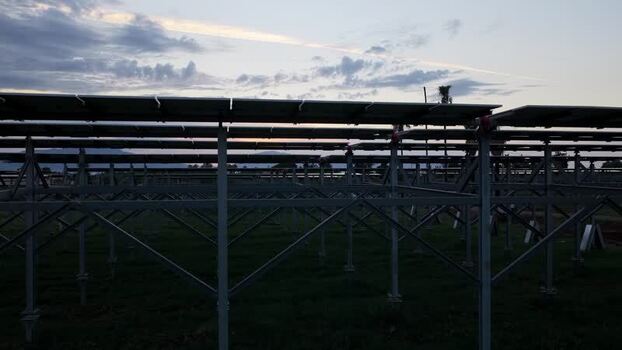 Aerial view of solar panels in a field at sunset Italy.