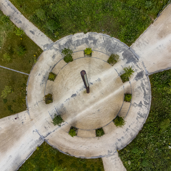 Aerial view of a circular structure with radiating pathways surrounded by verdant greenery a stark contrast of concrete against nature Utopia Flevoland Netherlands.