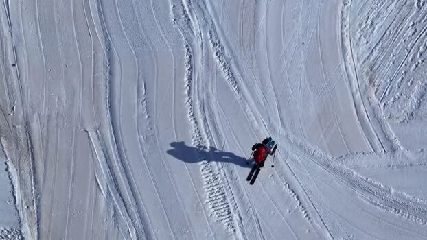 Aerial view of a skier on a snowy slope in Austria.