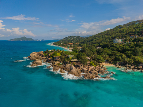 Aerial view of turquoise waters swirl around rocky outcrops fringed by lush green hillsides and pristine beaches La Retraite Mahe Island Seychelles. Aerial view of turquoise waters swirl around rocky outcrops fringed by lush green hillsides and pristine beaches La Retraite Mahe Island Seychelles.