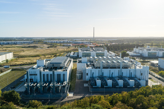 Aerial view of the Vantage Data Centers BER1 facility featuring modern white industrial buildings and cooling units in Ludwigsfelde Brandenburg Germany. Aerial view of the Vantage Data Centers BER1 facility featuring modern white industrial buildings and cooling units in Ludwigsfelde Brandenburg Germany.