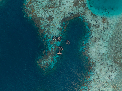 Aerial view of circular fish cages floating in the turquoise waters of a coral reef near Karimunjawa Jawa Tengah Indonesia. Aerial view of circular fish cages floating in the turquoise waters of a coral reef near Karimunjawa Jawa Tengah Indonesia.