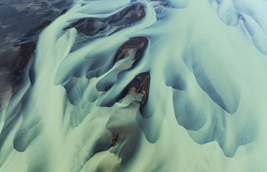 Aerial view of glacial rivers weaving through the stark landscape creating delicate patterns of turquoise against the dark earth Iceland Iceland. Aerial view of glacial rivers weaving through the stark landscape creating delicate patterns of turquoise against the dark earth Iceland Iceland.