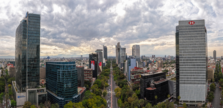 Mexico City Mexico 25 September 2026 Aerial view of the Paseo de la Reforma skyline with glass skyscrapers green trees lining the avenue and a cloudy sky over the urban landscape. Mexico City Mexico 25 September 2026 Aerial view of the Paseo de la Reforma skyline with glass skyscrapers green trees lining the avenue and a cloudy sky over the urban landscape.