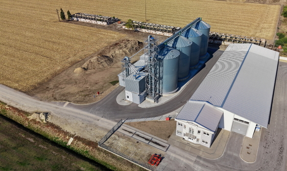 Aerial view of the storage silo Bavaniste facility with large metal grain bins a long warehouse and an office building surrounded by agricultural fields in Bavaniste Vojvodina Serbia.