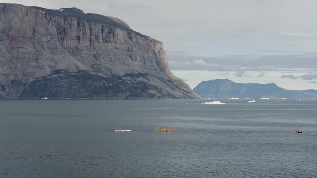 Aerial view of Uummannaq Mountain and kayaks in Greenland. Aerial view of Uummannaq Mountain and kayaks in Greenland.