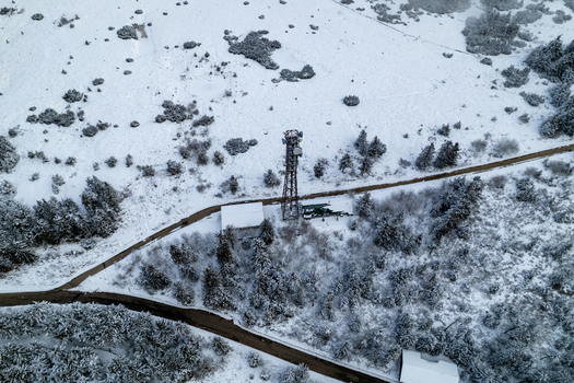 Aerial view of a communication tower surrounded by snow covered pine trees and a winding road near Mummelsee in Seebach Baden Wurttemberg Germany. Aerial view of a communication tower surrounded by snow covered pine trees and a winding road near Mummelsee in Seebach Baden Wurttemberg Germany.