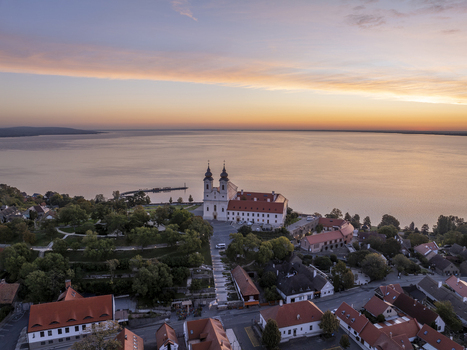 Aerial view of Tihany Abbey overlooking Lake Balaton at sunset with historic buildings and rooftops in the foreground in Tihany Hungary. Aerial view of Tihany Abbey overlooking Lake Balaton at sunset with historic buildings and rooftops in the foreground in Tihany Hungary.