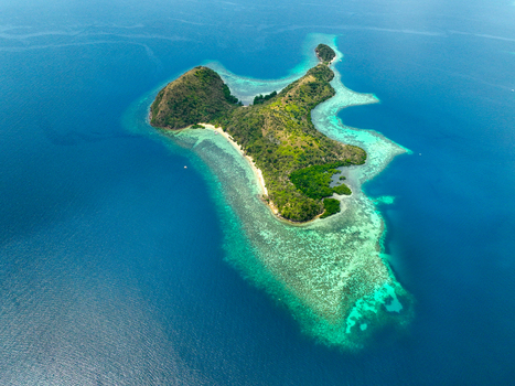 Aerial view of CYC Beach with its white sand shore lush green vegetation and vibrant turquoise coral reefs surrounded by the deep blue waters of the ocean in Coron Mimaropa Philippines. Aerial view of CYC Beach with its white sand shore lush green vegetation and vibrant turquoise coral reefs surrounded by the deep blue waters of the ocean in Coron Mimaropa Philippines.