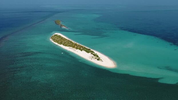 Aerial view of a tropical island and turquoise lagoon Maldives.