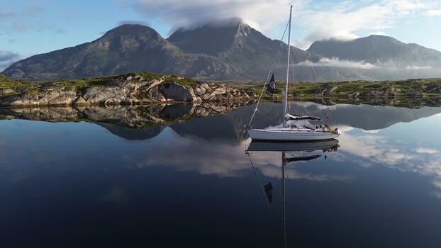 Aerial view of a sailboat on a calm fjord in Senja Norway. Aerial view of a sailboat on a calm fjord in Senja Norway.