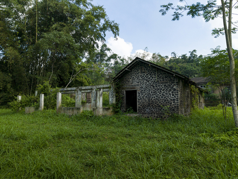 Aerial view of stone house ruins damaged by the Mount Merapi eruption surrounded by lush vegetation and trees in Cangkringan Special Region of Yogyakarta Indonesia. Aerial view of stone house ruins damaged by the Mount Merapi eruption surrounded by lush vegetation and trees in Cangkringan Special Region of Yogyakarta Indonesia.