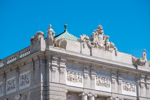 View of the ornate facade and classical sculptures of the Hofburg Palace under a clear blue sky in Vienna Vienna Austria. View of the ornate facade and classical sculptures of the Hofburg Palace under a clear blue sky in Vienna Vienna Austria.