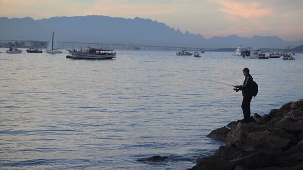 View of a man fishing at Guanabara Bay Brazil. View of a man fishing at Guanabara Bay Brazil.