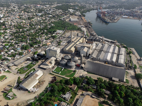Aerial view of the industrial complex with factory buildings storage silos and a nearby port in Bajos de Haina San Cristobal Province Dominican Republic.
