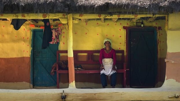 View of a woman sitting in front of a traditional house Nepal. View of a woman sitting in front of a traditional house Nepal.