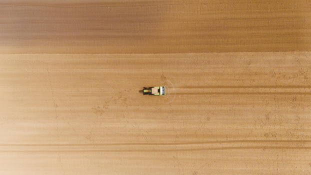 Aerial view of a lone tractor carving lines into the earth contrasting the freshly tilled soil with the untouched fields Sremska Mitrovica Vojvodina Serbia. Aerial view of a lone tractor carving lines into the earth contrasting the freshly tilled soil with the untouched fields Sremska Mitrovica Vojvodina Serbia.