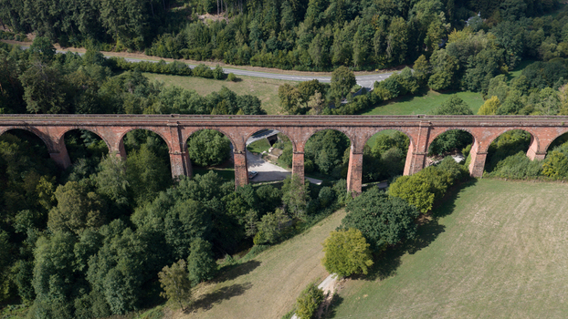Aerial view of the historic Himbachel Viadukt railway bridge surrounded by lush green forests and meadows in Erbach Hessen Germany. Aerial view of the historic Himbachel Viadukt railway bridge surrounded by lush green forests and meadows in Erbach Hessen Germany.