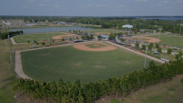 Aerial view of a baseball complex with multiple fields green grass dirt infields and surrounding trees in Polk City Florida United States. Aerial view of a baseball complex with multiple fields green grass dirt infields and surrounding trees in Polk City Florida United States.
