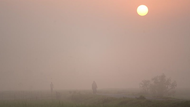 View of people walking through thick fog at sunrise Bangladesh. View of people walking through thick fog at sunrise Bangladesh.