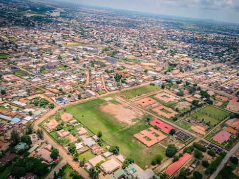 Aerial view of Barnawa district in Kaduna featuring residential houses a large open field and institutional buildings under a cloudy sky in Kaduna Kaduna Nigeria. Aerial view of Barnawa district in Kaduna featuring residential houses a large open field and institutional buildings under a cloudy sky in Kaduna Kaduna Nigeria.