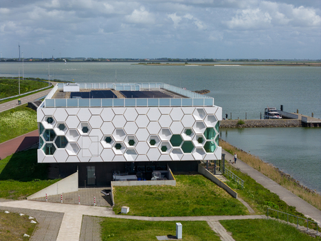 Kornwerderzand Netherlands 14 May 2026 Aerial view of Afsluitdijk Wadden Center featuring a white hexagonal facade and solar panels by the water under a cloudy sky. Kornwerderzand Netherlands 14 May 2026 Aerial view of Afsluitdijk Wadden Center featuring a white hexagonal facade and solar panels by the water under a cloudy sky.