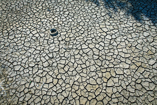 Aerial view of cracked dry earth and parched soil during a severe drought with a discarded tire Carignano Piemonte Italy. Aerial view of cracked dry earth and parched soil during a severe drought with a discarded tire Carignano Piemonte Italy.
