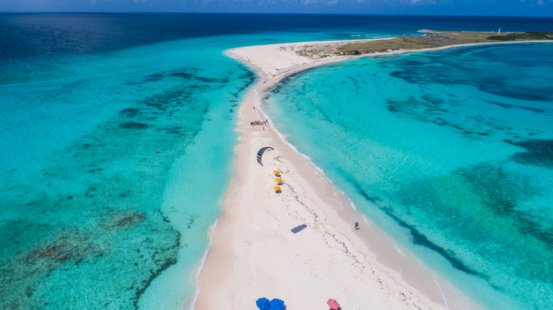 Aerial view of the white sandbar at Los Roques archipelago surrounded by turquoise waters with people and colorful umbrellas on the beach Los Roques Dependencias Federale Venezuela. Aerial view of the white sandbar at Los Roques archipelago surrounded by turquoise waters with people and colorful umbrellas on the beach Los Roques Dependencias Federale Venezuela.