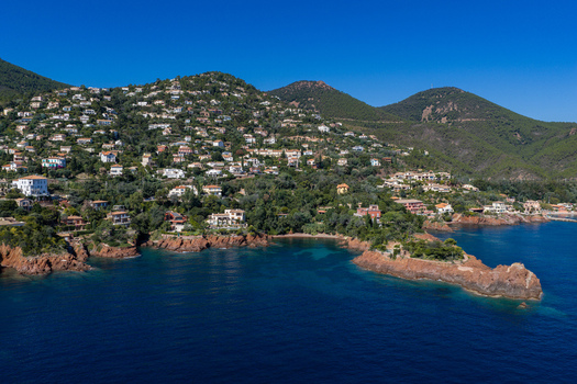 Aerial view of Le Trayas featuring Mediterranean villas nestled on lush green hillsides overlooking the deep blue sea and rocky coastline in Saint Raphael Provence Alpes Cote d Azur France. Aerial view of Le Trayas featuring Mediterranean villas nestled on lush green hillsides overlooking the deep blue sea and rocky coastline in Saint Raphael Provence Alpes Cote d Azur France.