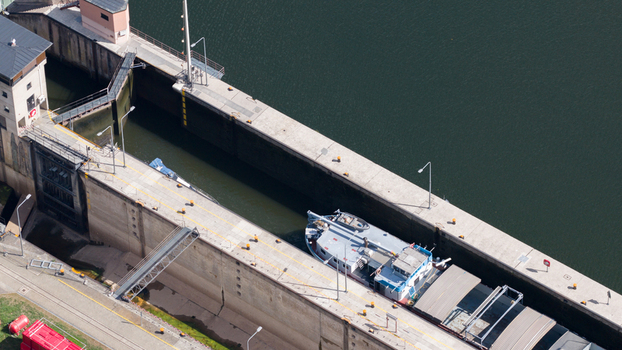 Aerial view of the Neckar Staustufe und Schleuse Rockenau with a cargo boat inside the concrete lock chamber on the Neckar river in Eberbach Baden Wurttemberg Germany.