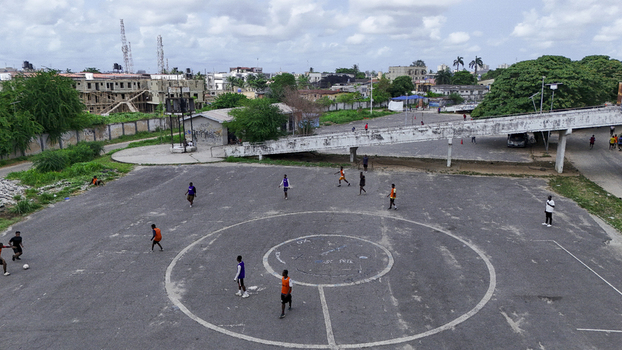 Aerial view of people playing football on a paved court with circular markings near a pedestrian bridge at the National Stadium Surulere Lagos in Lagos Lagos Nigeria. Aerial view of people playing football on a paved court with circular markings near a pedestrian bridge at the National Stadium Surulere Lagos in Lagos Lagos Nigeria.