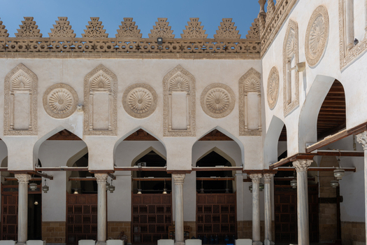 View of Al Azhar Mosque with its intricate stone carvings pointed arches and marble columns under a clear blue sky Cairo Egypt. View of Al Azhar Mosque with its intricate stone carvings pointed arches and marble columns under a clear blue sky Cairo Egypt.