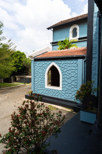View of a blue colonial style building with textured walls arched windows and terracotta tiled roofs under a bright sky Galle Southern Province Sri Lanka.