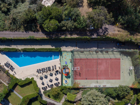 Aerial view of a swimming pool a tennis court and a playground area surrounded by lush greenery and trees in Istanbul Istanbul Turkiye. Aerial view of a swimming pool a tennis court and a playground area surrounded by lush greenery and trees in Istanbul Istanbul Turkiye.