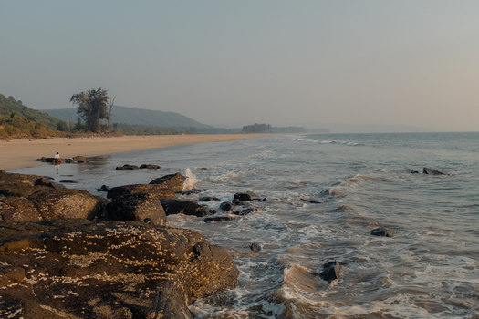 View of the sun kissed beach where the sea whispers secrets to the weathered rocks inviting a serene escape along the coast Chiplun Maharashtra India. View of the sun kissed beach where the sea whispers secrets to the weathered rocks inviting a serene escape along the coast Chiplun Maharashtra India.