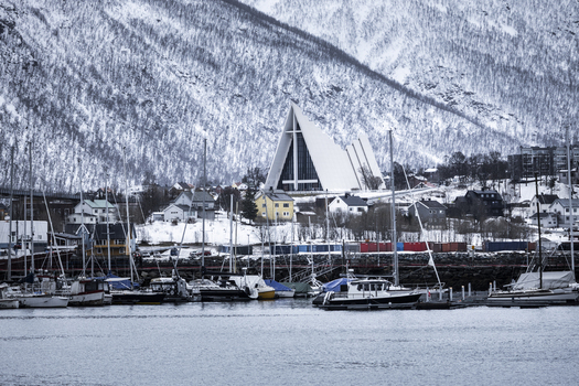 Tromso Norway 07 March 2026 View of the Arctic Cathedral across the harbor with boats in the marina and snow covered mountains in the background. Tromso Norway 07 March 2026 View of the Arctic Cathedral across the harbor with boats in the marina and snow covered mountains in the background.