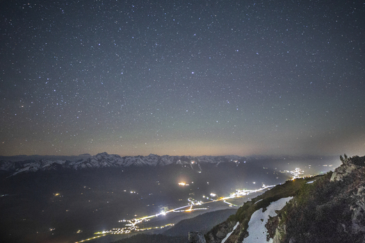 View of Stoderzinken mountain and the starry night sky over the illuminated valley and snow capped peaks Liezen Steiermark Austria. View of Stoderzinken mountain and the starry night sky over the illuminated valley and snow capped peaks Liezen Steiermark Austria.