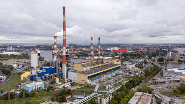 Gdansk Poland 24 September 2026 Aerial view of a power plant with tall chimneys located near the industrial port with ships and storage facilities under a cloudy sky.