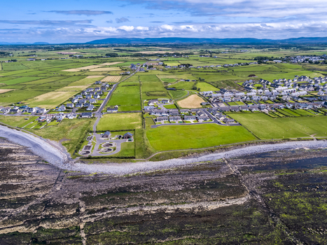 Aerial view of the water purification plant situated along the rocky coastline near residential neighborhoods and green fields in Enniscrone County Sligo Ireland. Aerial view of the water purification plant situated along the rocky coastline near residential neighborhoods and green fields in Enniscrone County Sligo Ireland.