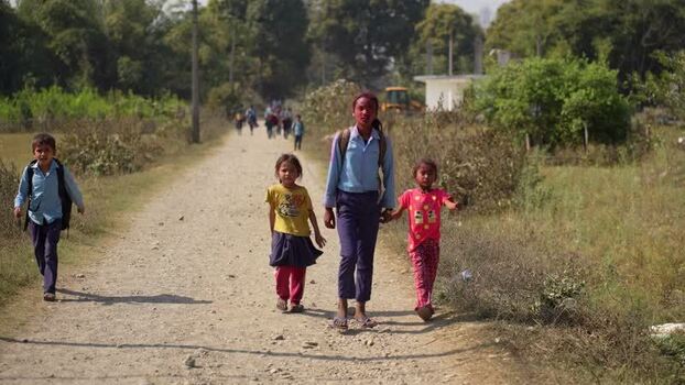 View of children walking on a rural dirt road in Dang Nepal.