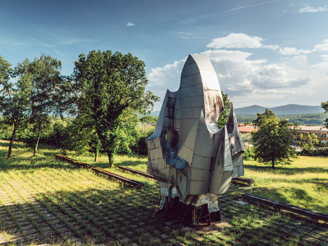 Aerial view of the abstract metal monument at Memorial park Susnjar surrounded by green trees and rolling hills in Sanski Most Federation of Bosnia Bosnia and Herzegovina.