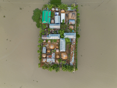 Mithamain Bangladesh 10 September 2025 Aerial view of an isolated village island surrounded by floodwaters featuring tin roofed houses and traditional thatched granaries. Mithamain Bangladesh 10 September 2025 Aerial view of an isolated village island surrounded by floodwaters featuring tin roofed houses and traditional thatched granaries.