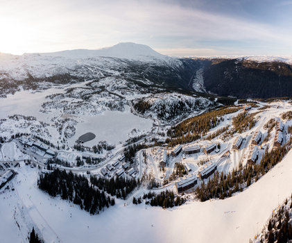 Aerial view of Gaustablikk Fjellresort surrounded by snow covered mountains ski slopes and a frozen lake in the winter landscape of Rjukan Telemark Norway. Aerial view of Gaustablikk Fjellresort surrounded by snow covered mountains ski slopes and a frozen lake in the winter landscape of Rjukan Telemark Norway.