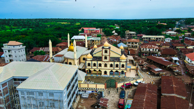 Aerial view of a prominent golden domed mosque with minarets nestled among dense red roofed buildings and green trees Igbaja Nigeria. Aerial view of a prominent golden domed mosque with minarets nestled among dense red roofed buildings and green trees Igbaja Nigeria.