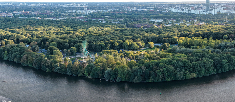 Aerial view of the abandoned Spreepark amusement park featuring its iconic Ferris wheel surrounded by dense forest and the Spree river in Berlin Berlin Germany. Aerial view of the abandoned Spreepark amusement park featuring its iconic Ferris wheel surrounded by dense forest and the Spree river in Berlin Berlin Germany.