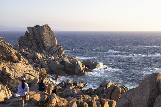 View of Capo Testa granite rock formations with people overlooking the Mediterranean Sea during golden hour in Capo Testa Sardegna Italy. View of Capo Testa granite rock formations with people overlooking the Mediterranean Sea during golden hour in Capo Testa Sardegna Italy.