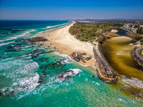Aerial view of Cudgen Headland South Head featuring the rocky breakwater turquoise ocean waters sandy beach and lush coastal vegetation in Kingscliff New South Wales Australia. Aerial view of Cudgen Headland South Head featuring the rocky breakwater turquoise ocean waters sandy beach and lush coastal vegetation in Kingscliff New South Wales Australia.