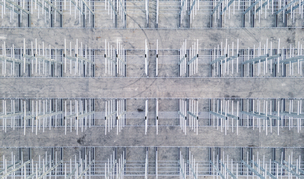 Aerial view of a multi level vehicle storage structure with rows of metal frames on a concrete surface in Livron sur Drome Auvergne Rhone Alpes France. Aerial view of a multi level vehicle storage structure with rows of metal frames on a concrete surface in Livron sur Drome Auvergne Rhone Alpes France.