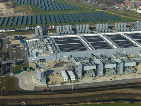 Aerial view of the Google data center featuring large industrial buildings cooling units and a solar panel farm in Winschoten Groningen Netherlands.
